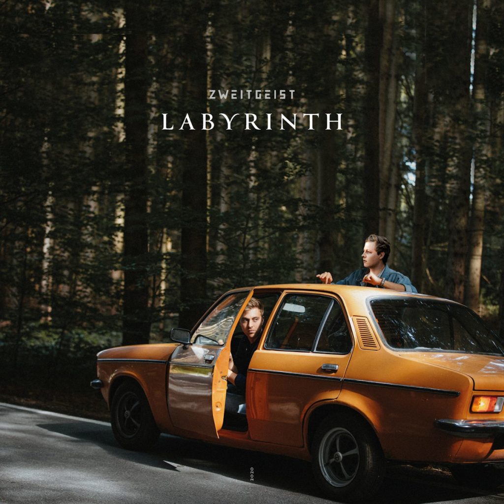 Zweitgeist sind ein Münchner Singer-Songwriter-Duo und stehen auf dem Plattencover zu "Labyrinth" mit einem oragnenen Oldtimer im Wald