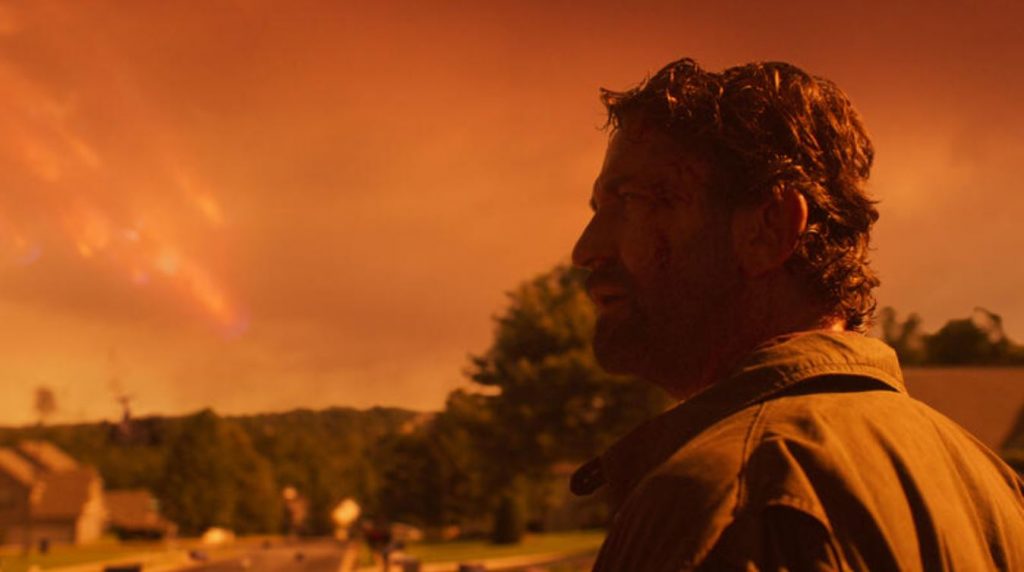 Wann kommt Greenland 2? Das Szenenbild zeigt Hauptdarsteller Gerard Buttler vor einer Farm in den USA. Im Hintergrund geht ein Kometenregen auf die Erde nieder.