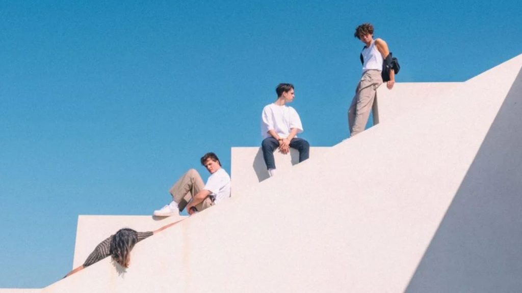 Jeremias live in München. Das Bild zeigt die Bandmitglieder auf einer weißen Treppe vor blauen Himmel. Ob das Bild in München aufgenommen wurde, ist nicht bekannt.