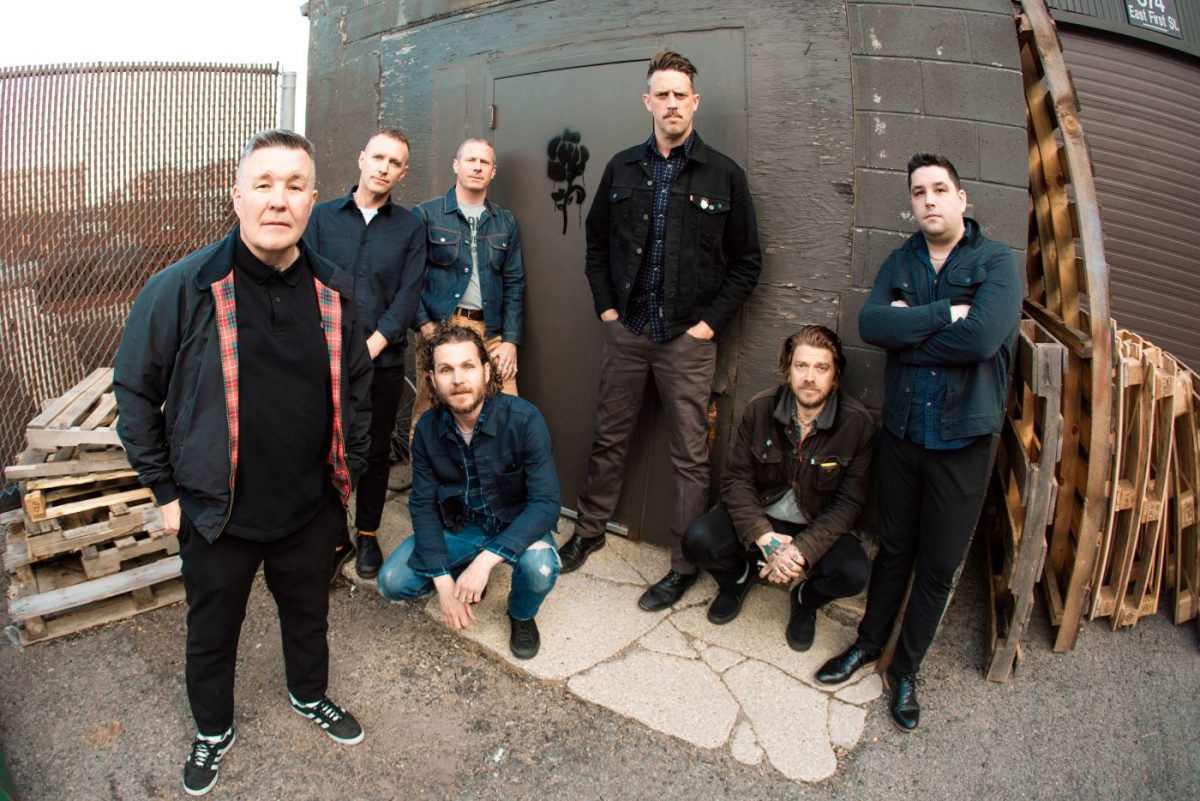 Bandfoto der Dropkick Murphys mit Ken Casey, Tim Brennan, Jeff DaRosa, Matt Kelly, James Lynch und Kevin Rheault, die gemeinsam stehen und ihre typische Mischung aus Folk und Punk ausstrahlen – passend zum Dropkick Murphys Ticket-Gewinnspiel beim Tollwood Sommerfestival 2026 in München