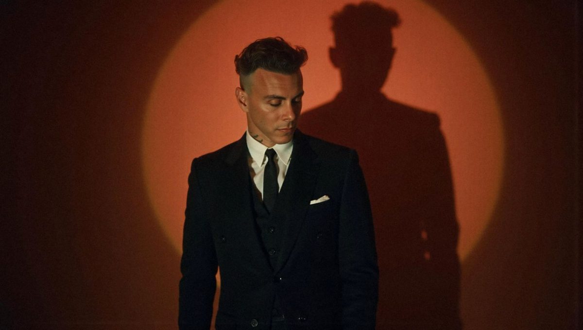 Alt-Text: LP und Asaf Avidan live in München Asaf Avidan im Anzug auf der Bühne mit Schatten