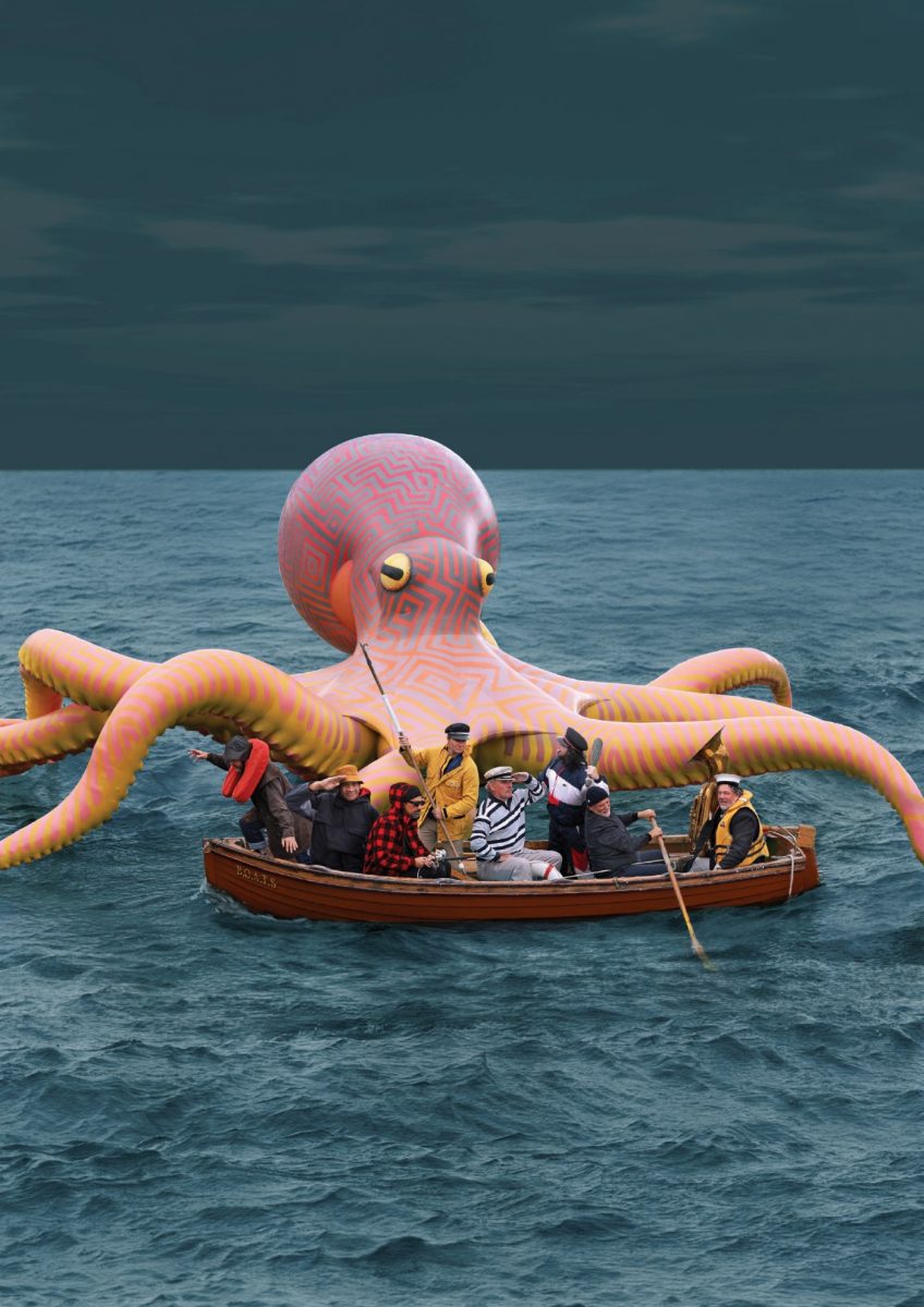 Alt-Text: Fat Freddy’s Drop live in München Band im Boot mit großem Oktopus im Hintergrund