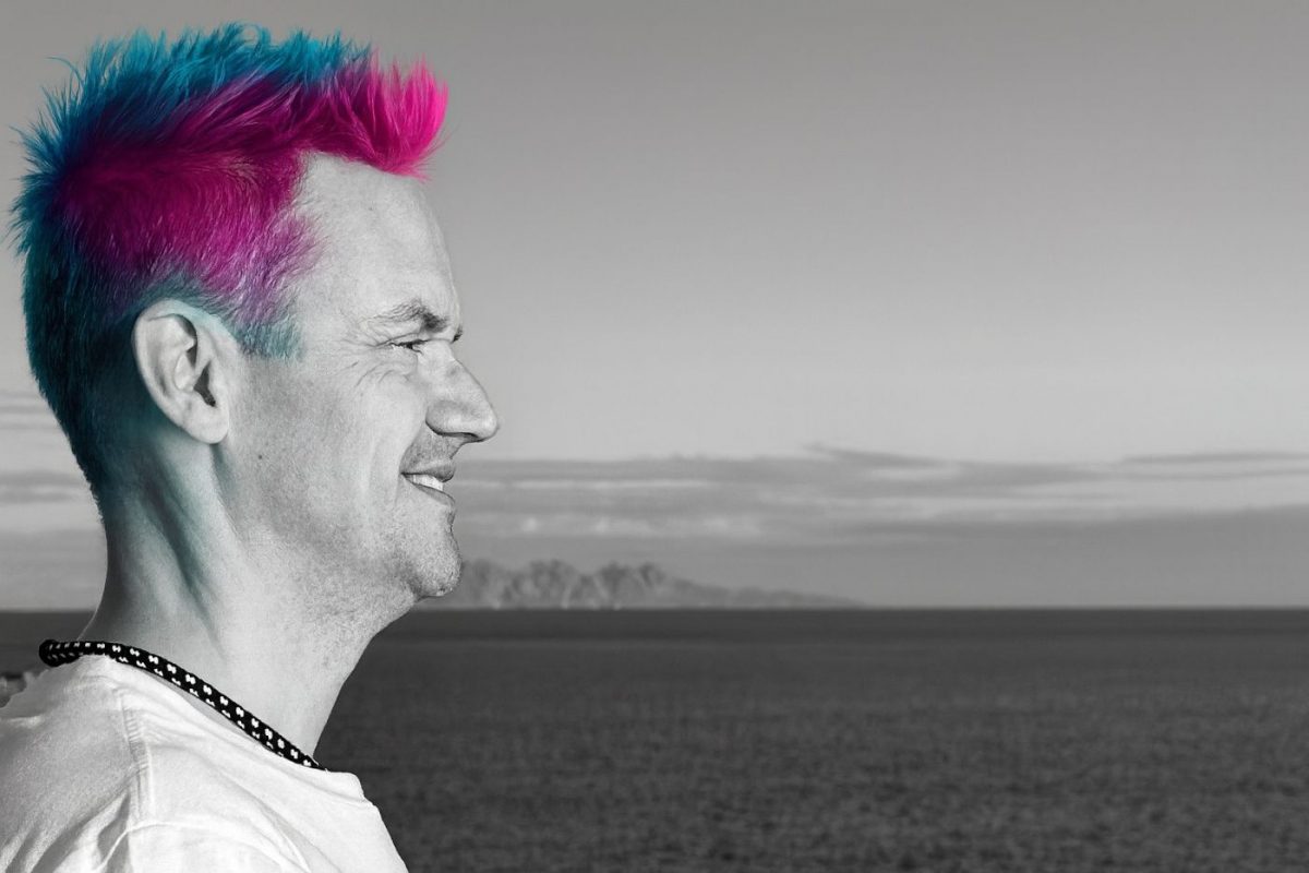 Manksy auf einem Pressefoto im Profil vor Wasserlandschaft zur Single Blumen